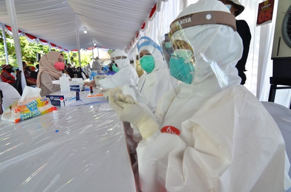 Swab test dilakukan oleh petugas medis kepada warga yang dinyatakan reaktif dalam rapid test. SP/Arlana