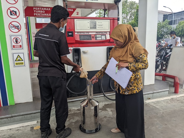 Pengawas Ke Meteorologi Diskopukmperindag Kota Mojokerto saat mengecek akurasi takaran BBM pada SPBU.