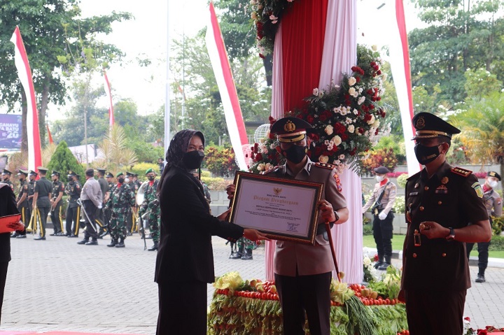 Kapolres Batu AKBP I Nyoman Yogi Hermawan menerima piagam penghargaan di Halaman Balai Kota Among Tani Kota Batu, Minggu (17/10/2021). SP/hms/herman