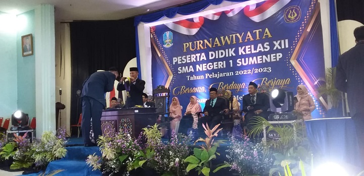Kepsek SMAN I Sumenep, Drs. Achmad Sulaiman, M.Pd, saat mengalungkan bunga kepada sejumlah siswa yang di Wisuda di Gedung Korpri Kab. Sumenep. SP/Ainur Rahman