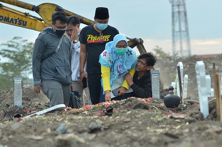 Beberapa peziarah mendatangan Tempat Pemakan Umum (TPU) khusus korban covid di TPU Keputih, Surabaya, Kamis (12/8/2021). 