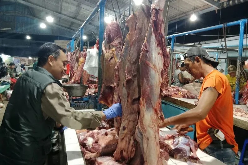Petugas Dispertan Banyuwangi saat mengecek kondisi daging sapi di Pasar Blambangan, Senin (17/4/2023). Foto: Pemkab Banyuwangi.