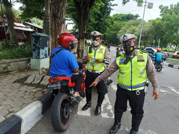 Petugas Satlantas Polres Gresik mengamankan motor berknalpot brong dalam sebuah operasi di jalan utama Kota Gresik. SP/Grs