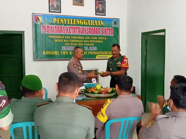Pemotongan tumpeng oleh Iptu Agus Purnomo ke Danramil Kapten Inf Guntoro. SP/Hadi Lestariono