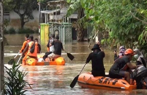 Petugas menggunakan perahu untuk mengevakuasi korban banjir. SP/Lim