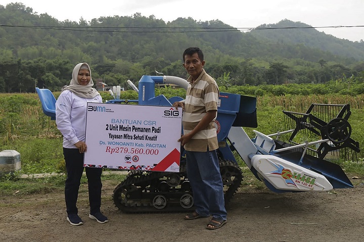 CSR Program BUMN Officer SIG, Sri Wahyuningsih menyerahkan bantuan alat pemanen padi kepada perwakilan Kelompok Mitra Sehati Kreatif, Hariadi. SP/M.AIDID
