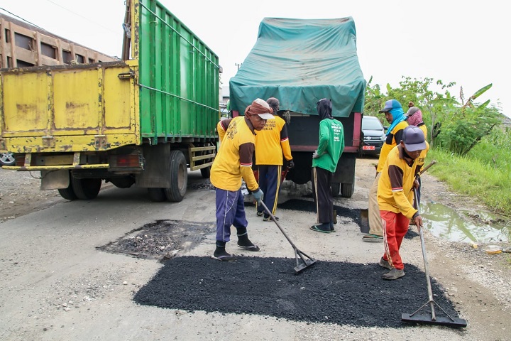 Pekerja tengah menambal sejumlah jalan yang berlubang. SP/MUHAJIRIN KASRUN