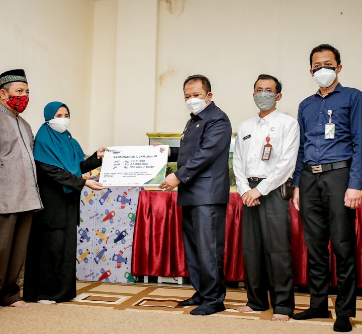 Bupati Jember Hendy Siswanto menyerahkan santunan kematian dari BPJS kepada keluarga almarhum Kades Ajung Kecamatan Kalisat, Mohamad Imron (Alm), Rabu (14/07/2021). SP/Dik