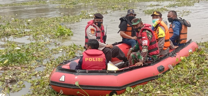 Petugas mencari korban perahu penerbangan yang terbalik di Sungai Bengawan Solo. SP/Her