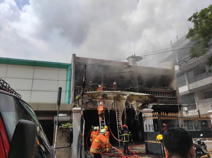 Petugas pemadam saat berupaya memadamkan api yang membakar rumah milik Windoyo Halim (70), di Jalan Taman AIS  Nasution 31, Panglima Sudirman, Senin (15/2/2021) siang.  SP/Mahbub Fikri