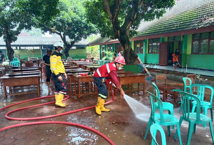 Tim CSR dan K3 Semen Indonesia saat membersihkan fasilitas pendidikan pasca banjir.