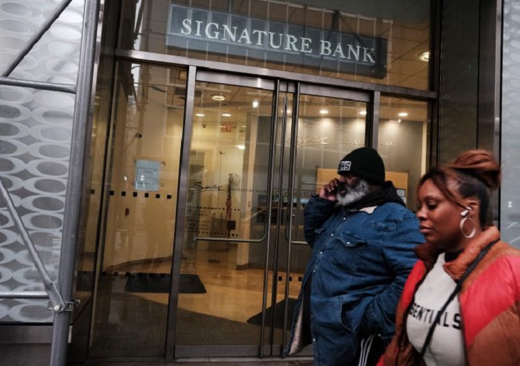 Orang-orang berjalan di dekat Signature Bank cabang Manhattan yang ditutup regulator bank pada Minggu (13/03/2023). SP/ SBY