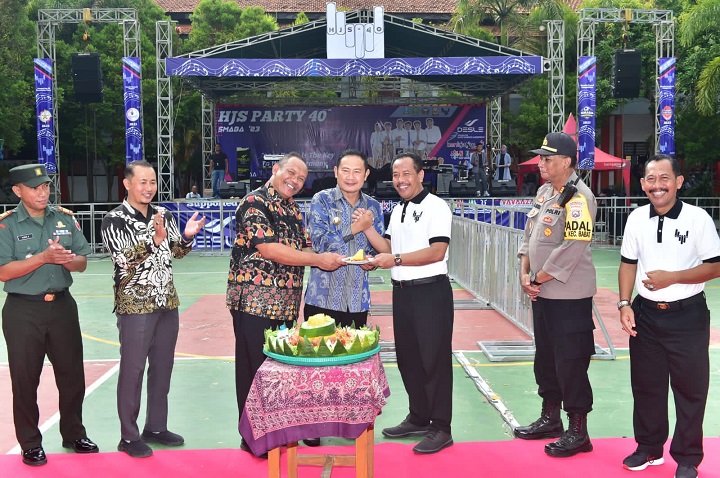 Bupati saat memberikan potongan tumpeng ke kepala sekolah SMAN 1 Babat Lamongan. SP/MUHAJIRIN KASRUN