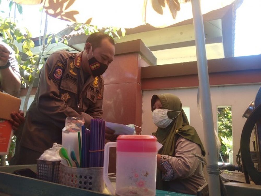 Satpol PP Kota Mojokerto memberi hadiah uang Rp. 50 ribu kepada warga yang tertib bermasker. SP/Dwy