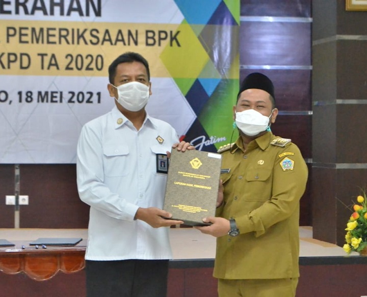 Bupati Fandi Akhmad Yani menerima Buku Laporan Keuangan WTP dari Kepala Perwakilan BPK Jatim Joko Agus Setyono, Selasa (18/5). SP/GRS