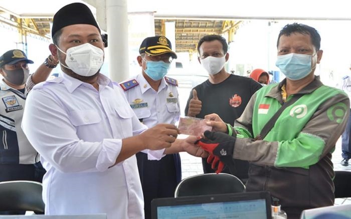 Bupati Gresik, Gus Yani, didampingi Kadishub Kabupaten Gresik, Tursilowanto, saat menyerahkan bantuan kepada pengemudi ojek daring.