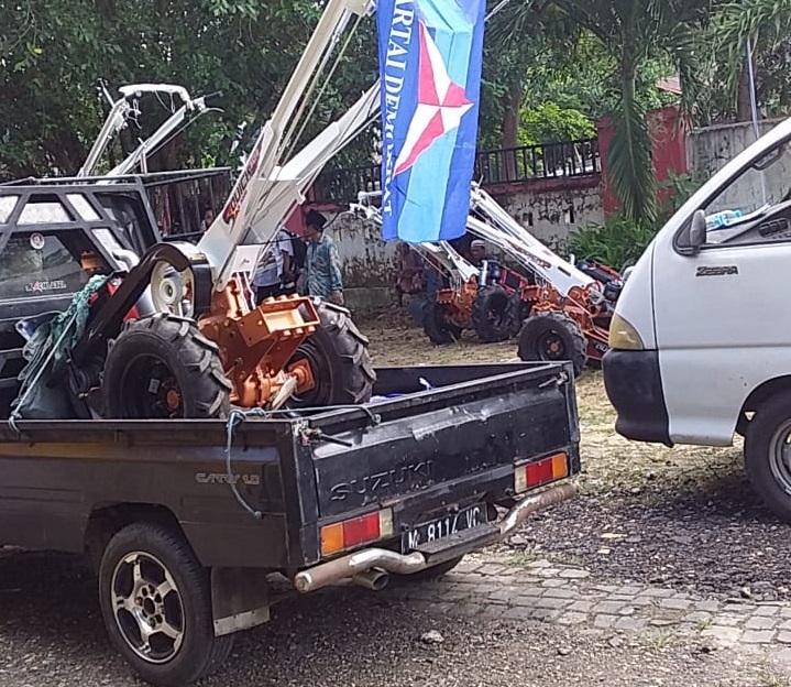 Bantuan Hand Traktor untuk Kelompok Tani dengan kibaran bendera Parpol diangkut oleh Mobil Pick up oleh penerima manfaat di kab. Sumenep. SP/Ainur Rahman