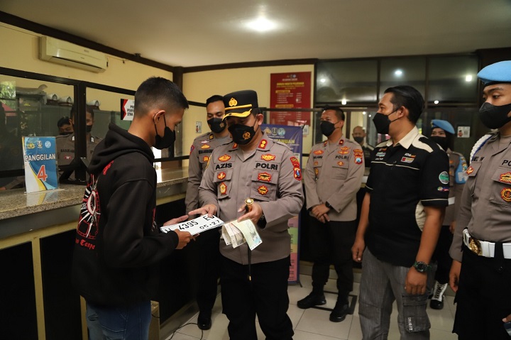 Kapolres AKBP Mochamad Nur Azis memberikan langsung STNK perpanjangan kepada seorang pemohon di kantor pelayanan Samsat Jl Wahidin Sudirohusodo Gresik. SP/Grs