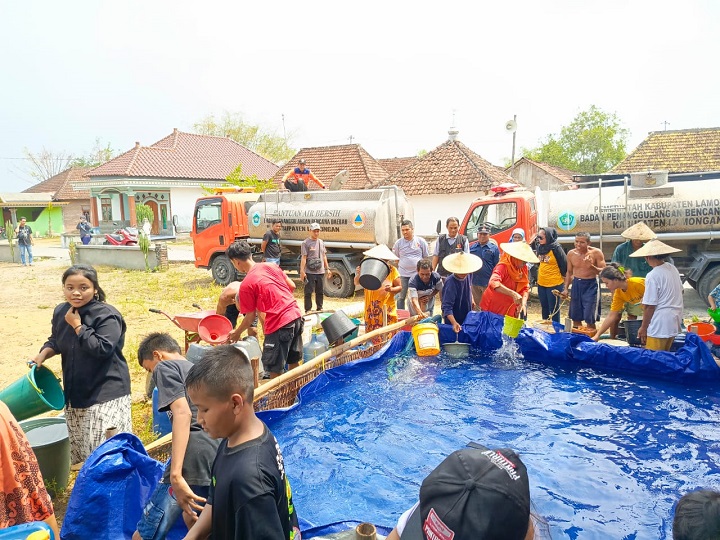 Warga masyarakat terdampak kekeringan saat menerima bantuan air bersih dari Bawaslu. SP/MUHAJIRIN 