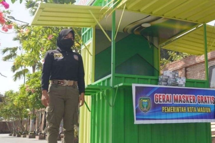 Petugas bersiaga di gerai masker yang ada di kawasan Taman Sumber Wangi Kota Madiun.