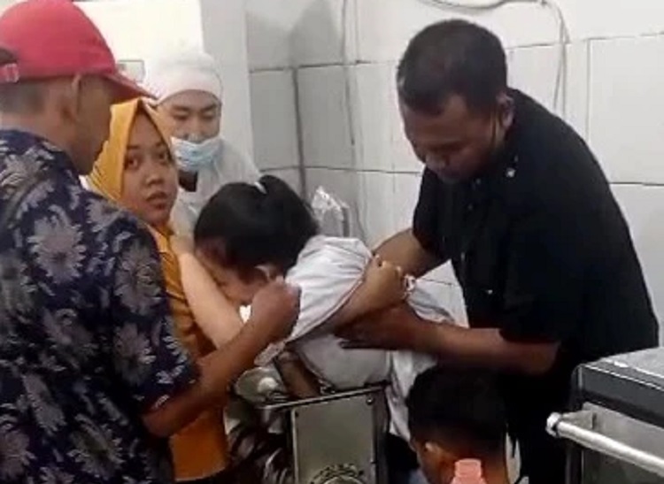 Tim Damkar BPBD Kabupaten Mojokerto dan relawan berusaha melepas tangan korban dari mesin penggilingan, Minggu (23/07/2023). SP/ MJK