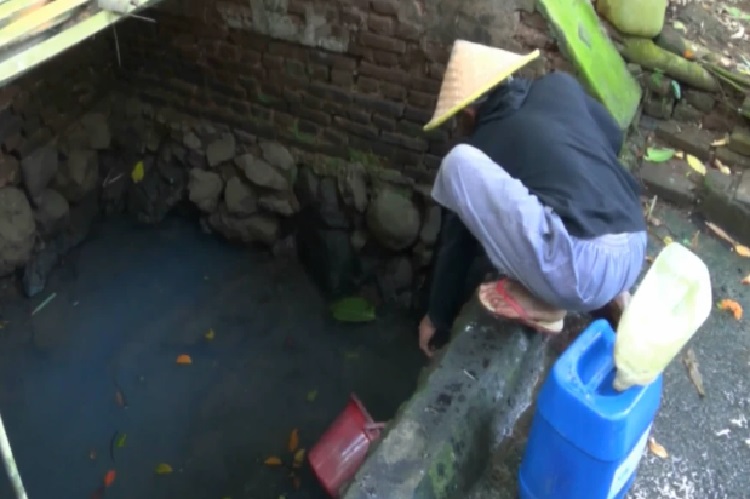 Salah satu warga yang rela antri berjam-jam untuk mendapatkan pasokan air bersih di 'Belik' atau sumber air. SP/ BLT