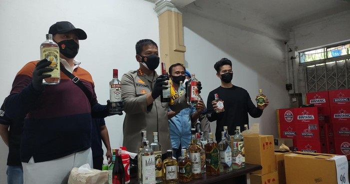 Polisi menunjukkan sejumlah botol miras hasil penggerebekan di perumahan Pondok Mutiara blok N15