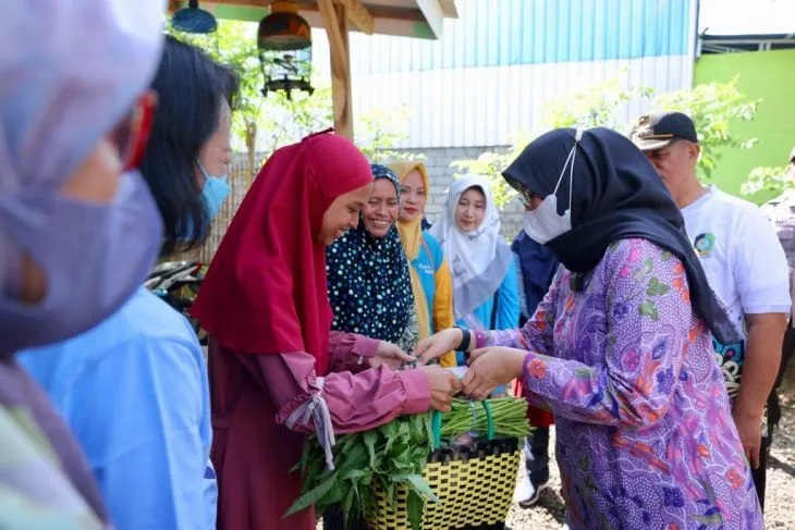 Bupati Banyuwangi Ipuk Fiestiandani membagikan hasil belanjaan kepada masyarakat di sekitar kawasan Pasar Galekan, Banyuwangi, Jumat (5/5/2023). Foto: Pemkab Banyuwangi.