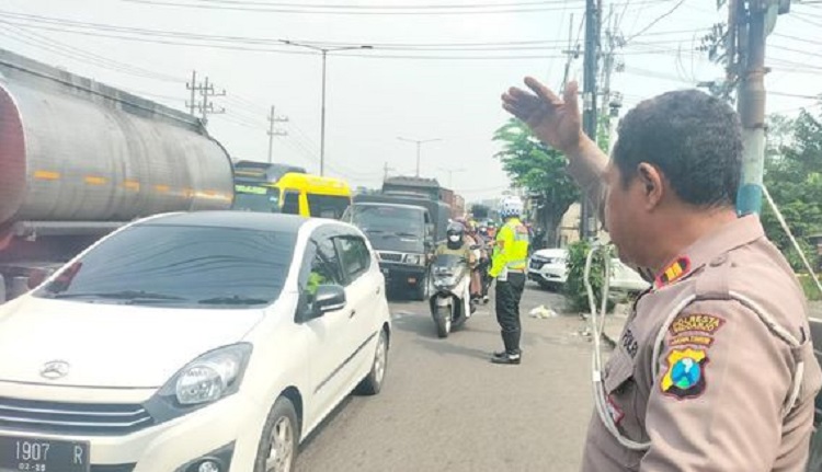Polisi setempat saat mengevakuasi korban kecelakaan, serta mengatur lalu lintas jalan yang macet akibat kejadian tersebut. SP/ SDR
