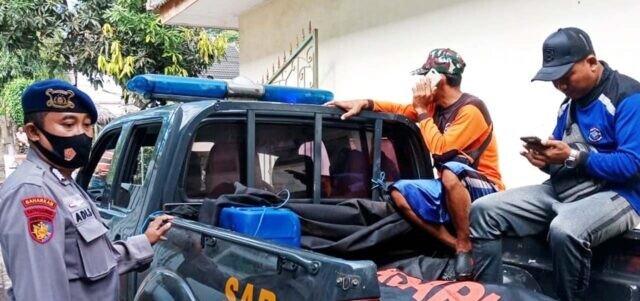 Petugas mengevakuasi jenazah korban.