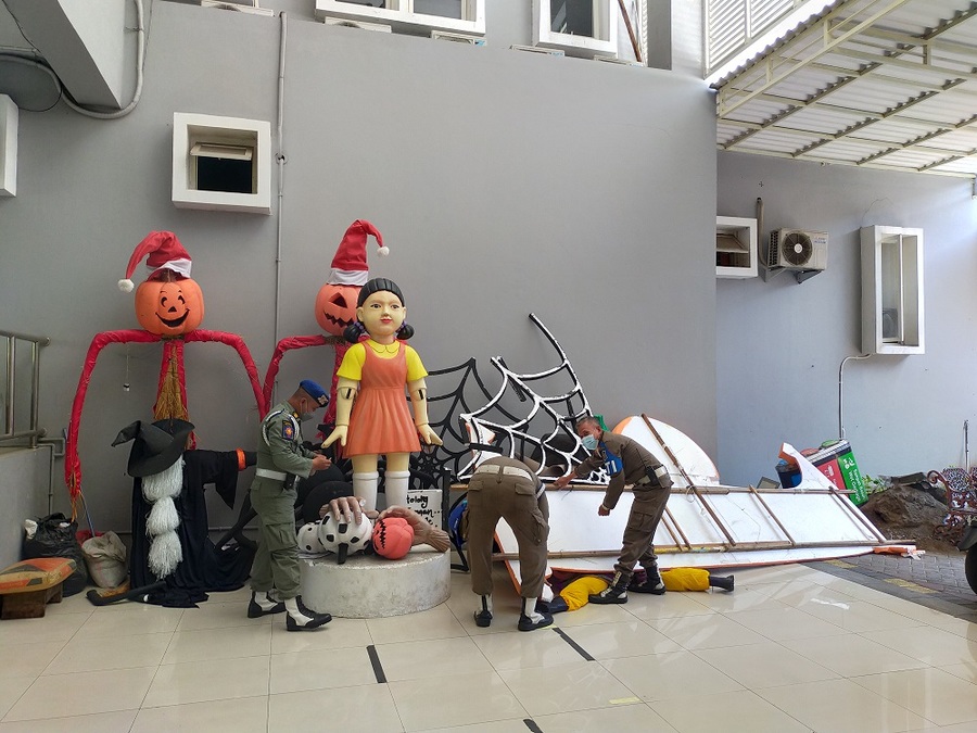 Petugas gabungan dari Satpol PP, Linmas dan Satgas Covid-19 Kota Surabaya membongkar replika boneka Squid Game yang berdiri di Jalan Tunjungan pada Minggu (10/10/2021) malam . SP/HUMAS PEMKOT SURABAYA