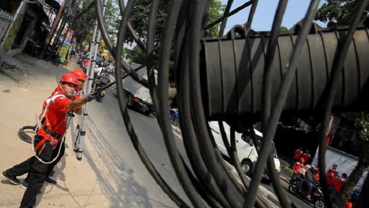 Pekerja yang membenahkan kabel milik Telkom