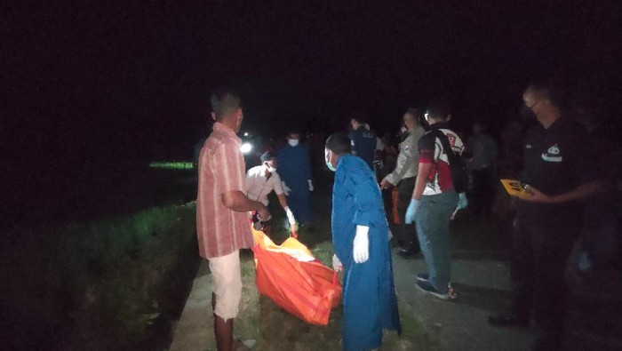 Petugas saat mengevakuasi jenazah korban.