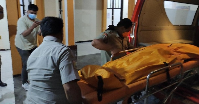 Petugas membawa kenazah korban ke kamar mayat untuk diotopsi.