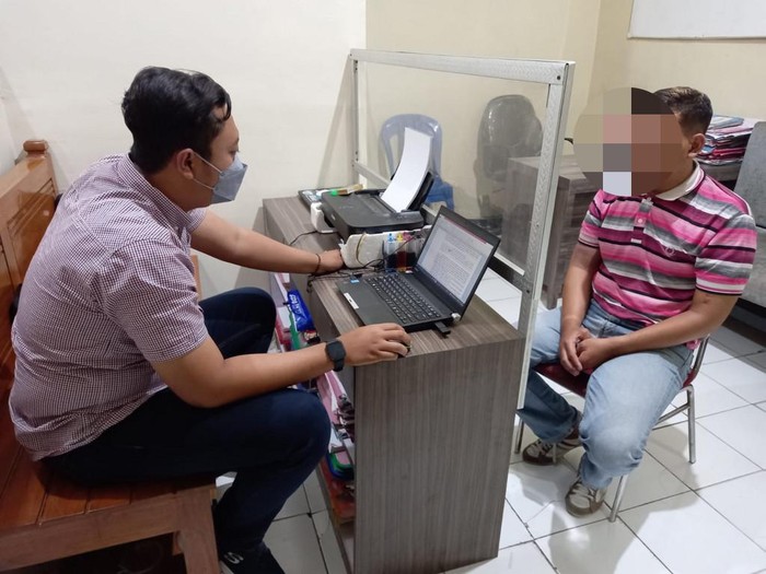 Pelaku saat diperiksa petugas. 