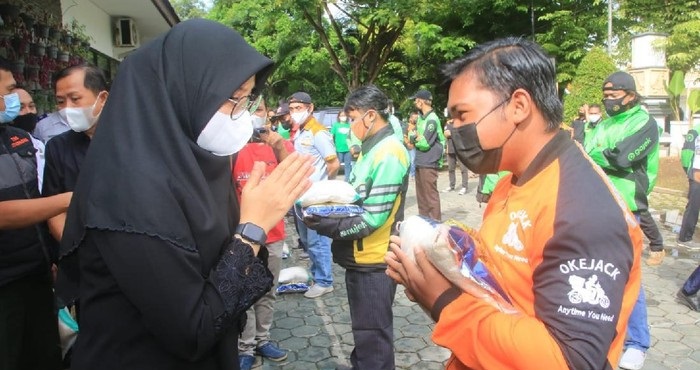 Bupati Banyuwangi Ipuk Fiestiandani secara simbolis menyerahkan langsung bantuan kepada 199 ojol, Selasa (3/8/2021). SP/Pemkab Banyuwangi