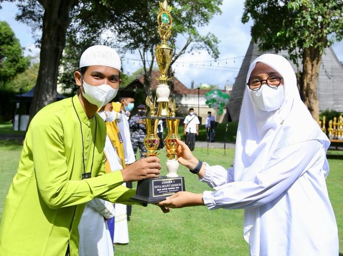 Bupati Banyuwangi Ipuk Fiestiandani menyerahkan piala kepada salah satu santri. 