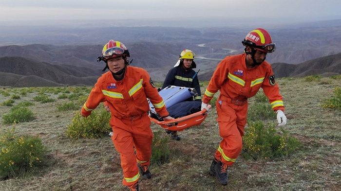 Sejumlah personil tim penyelamat yang dikerahkan dalam operasi penyelamatan para peserta lomba lari ultramaraton di kawasan Hutan Batu Sungai Kuning di Baiyin, China, Minggu (23/5/2021). SP/ AFP