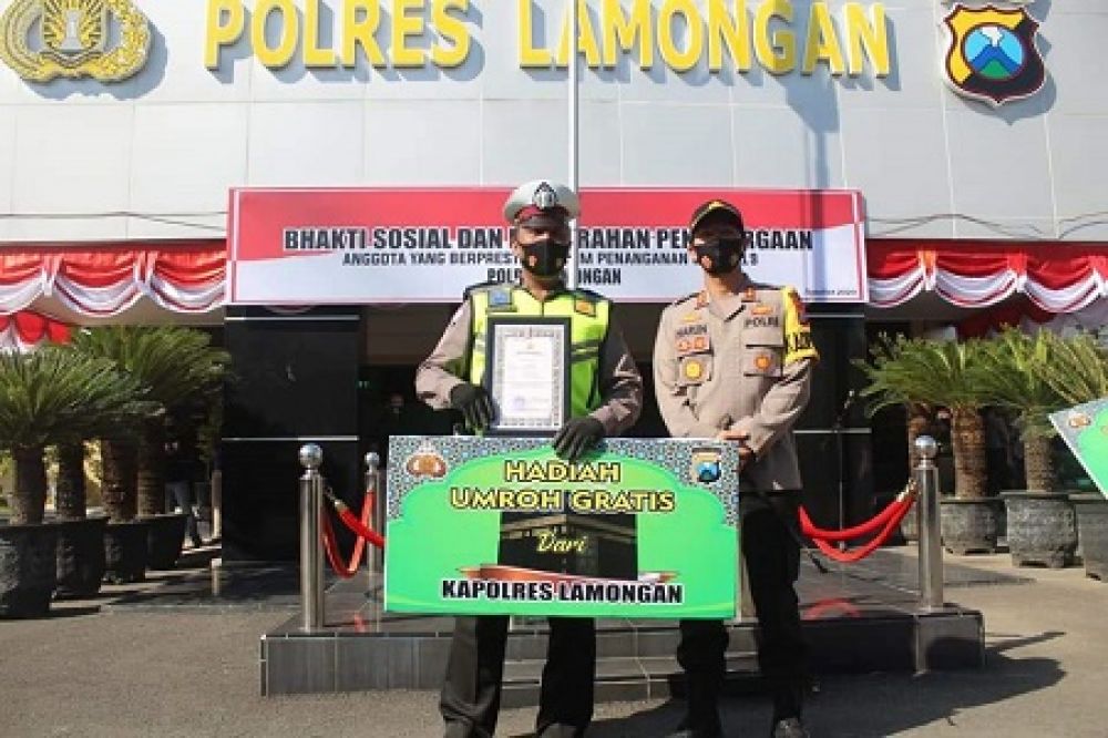 Aipda Purnomo saat menerima penghargaan dan hadiah umroh dari Kapolres Lamongan AKBP Harun. SP/Jir