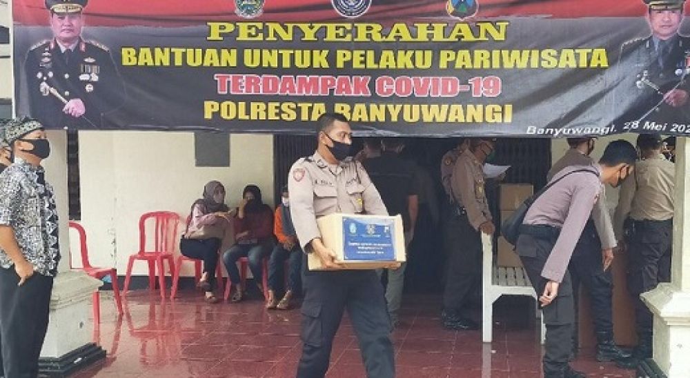 Petugas dari Polresta Banyuwangi mendistribusikan paket bantuan dari Kemenpar RI kepada para pelaku wisata yang terdampak covid-19. 