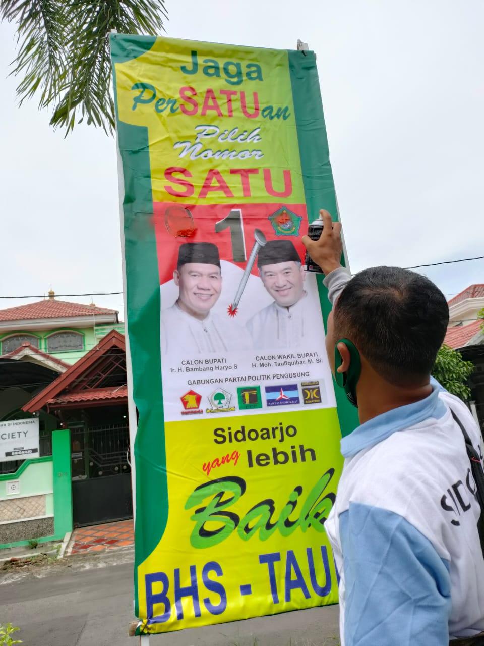 tim paslon BHS-Taufiqulbar saat perbaiki poster bermasalah
