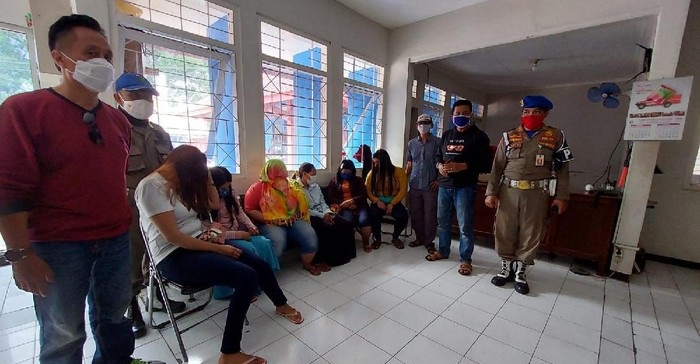 Petugas membawa para PSK yang terjaring razia untuk didata.