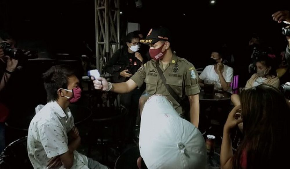 Beberapa anggota Satpol PP saat merazia jam malam di salah satu warkop di kawasan Pandegiling Surabaya, Sabtu dini hari kemarin.

Foto: Sp/arlana byob