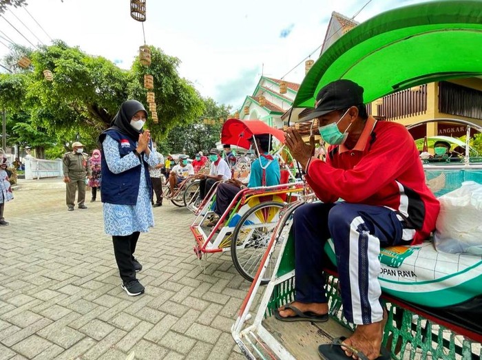 Bupati Banyuwangi Ipuk Fiestiandani membagikan bantuan ke pengemudi becak.