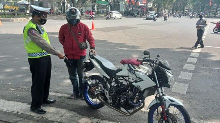 Petugas menghentikan salah satu pengendara yang menggunakan knalpot brong.