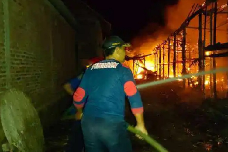 Petugas Damkar Magetan saat memadamkan kandang yang terbakar di  Kabupaten Ngawi, Jumat (21/7/2023) pukul 04.00 WIB dini hari. SP/ NGW