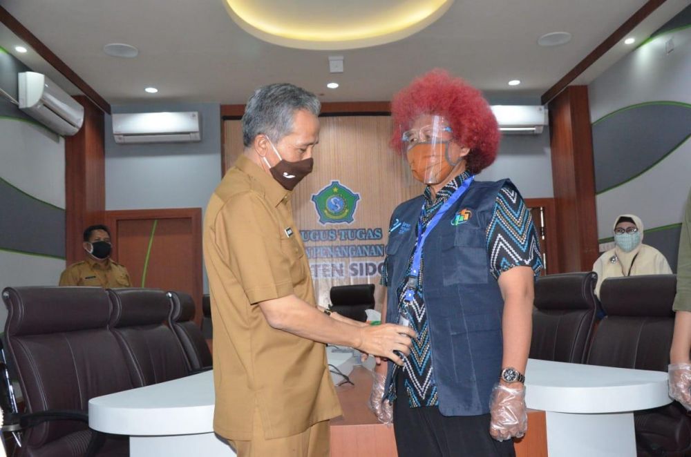 Plh Bupati Sidoarjo Achmad Zaini memasangkan rompi sensus penduduk.SP/SUGENG