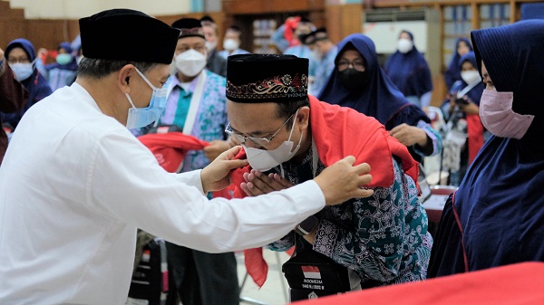 Direktur SDM dan Umum SIG, Agung Wiharto (kiri) menyematkan syal kepada Eko Cahyono, jemaah Calon Haji yang juga karyawan SIG saat pemberangkatan jemaah haji SIG di Wisma A. Yani, Gresik, Jawa Timur, Rabu (15/6).