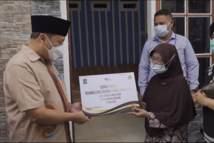 Kepala Dinas Sosial Kota Surabaya Suharto Wardoyo secara simbolis menyerahkan bantuan program Rutilahu kepada salah satu lansia MBR di Surabaya. 