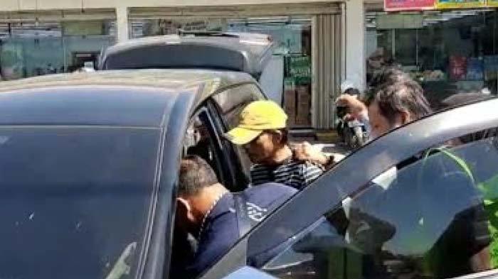 Pelaku (bertopi) ditangkap petugas di depan Indomaret di Tuban.